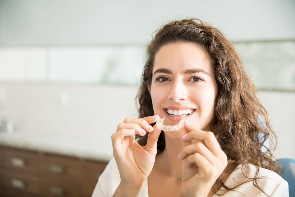 woman holding invisalign retainer