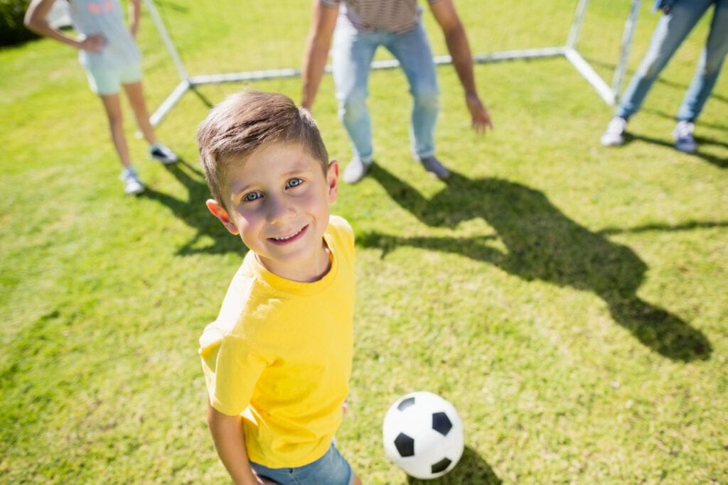 child playing soccer outside