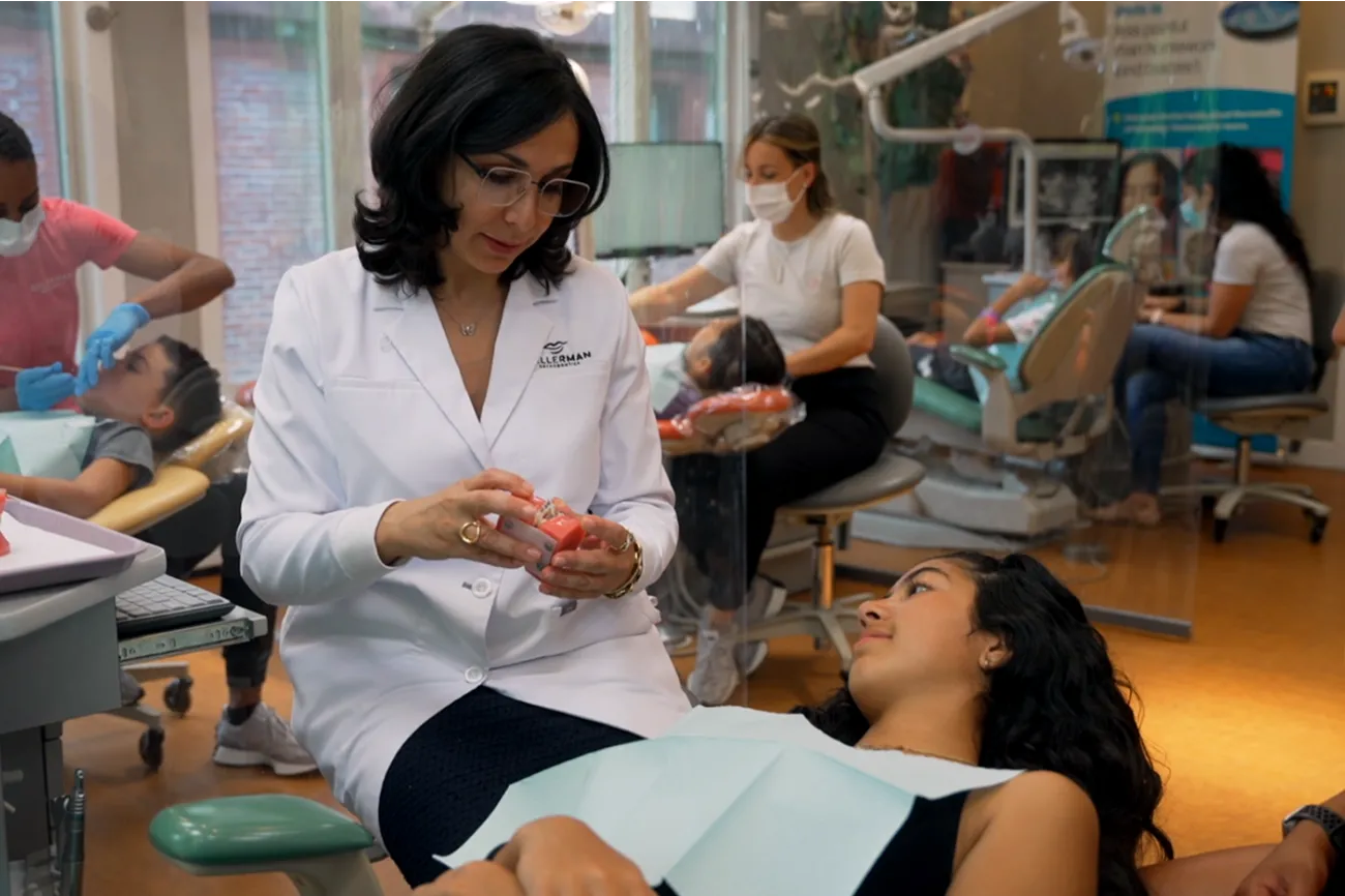 Orthodontist demonstrating MARPE device to patient in dental clinic, showcasing innovative palatal expansion treatment for sleep apnea and misaligned teeth.